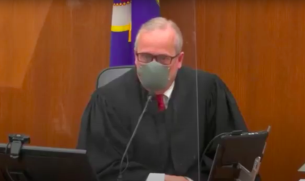 Judge Peter Cahill, masked, presiding of the trial.